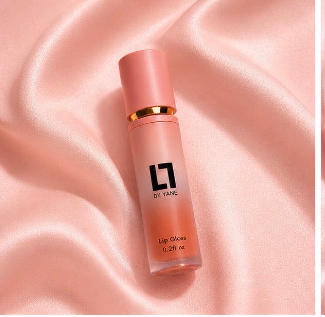 Lips and Lashes by Yane Lip Gloss in Peach Pearl on pink satin