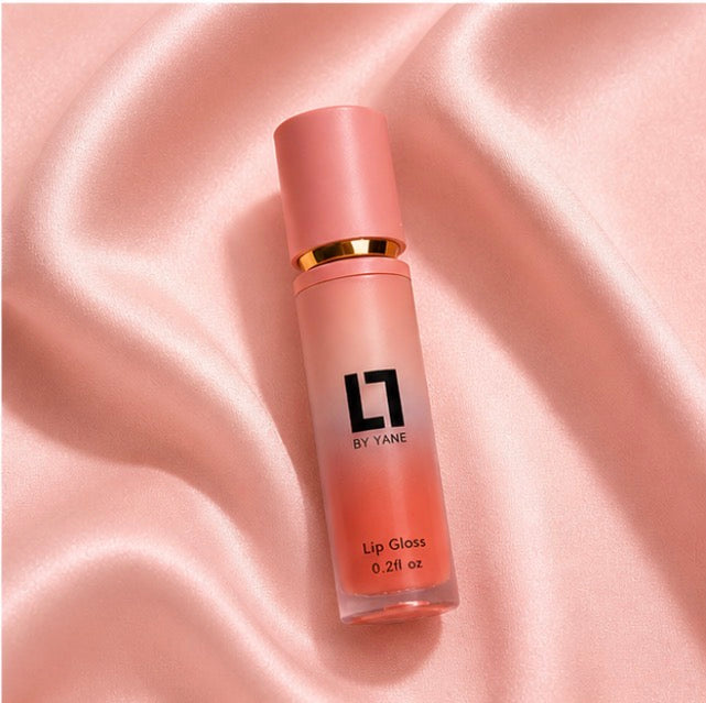 Lips and Lashes by Yane Lip Gloss in Sugar Coral on pink satin